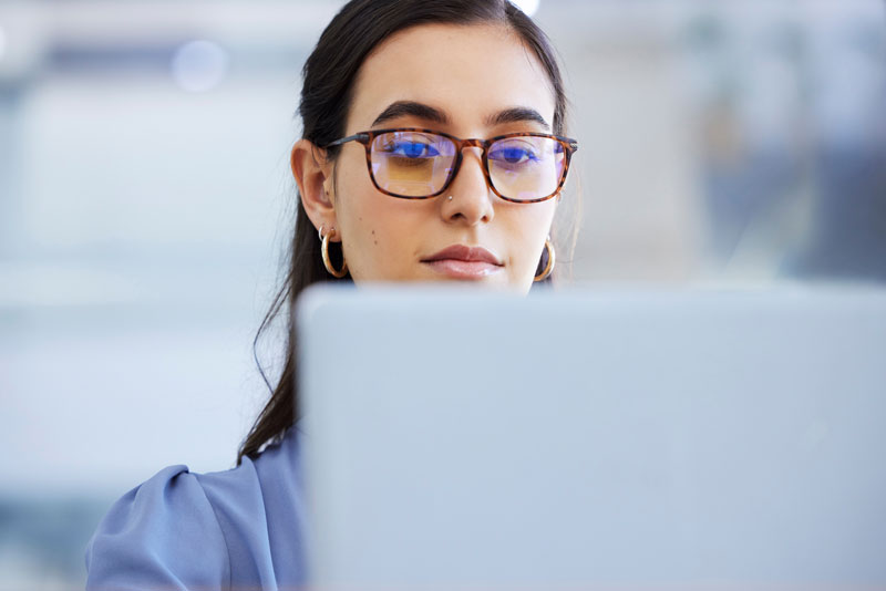 a woman looks at her computer screen